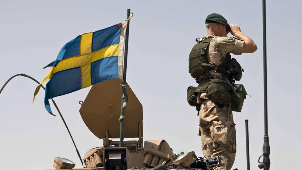 En svensk militär som tittar i en kikare.