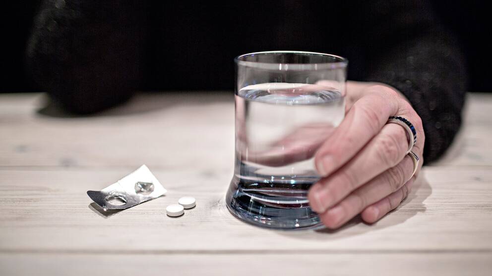 Smärtstillande tabletter och ett vattenglas