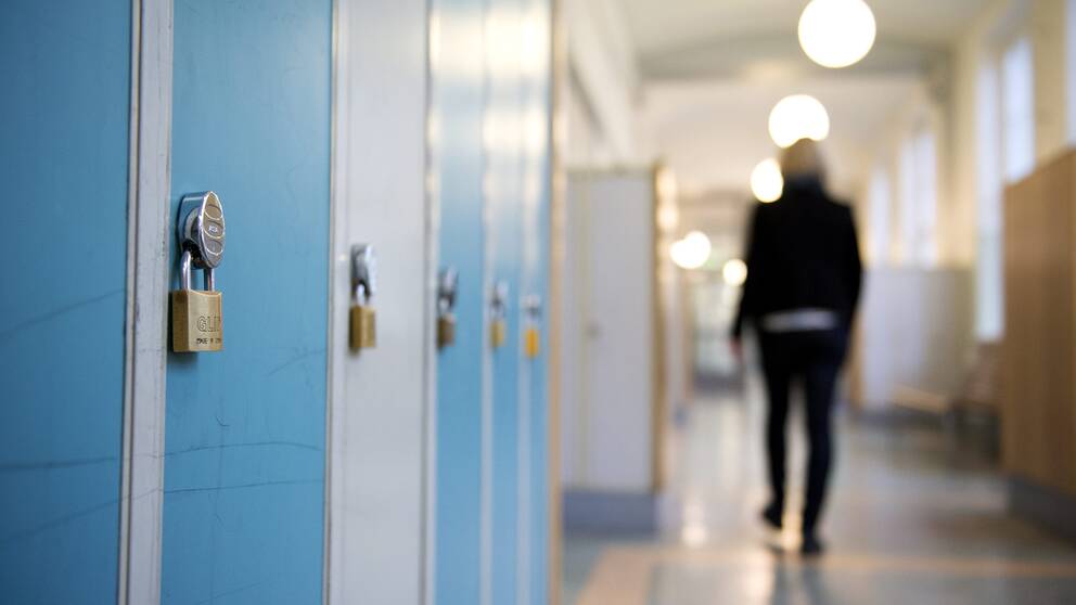 En elev går i skolkorridor.