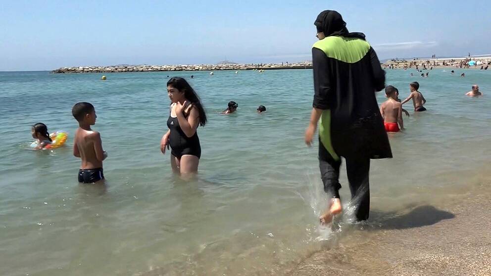 En kvinna iförd burkini på en strand.
