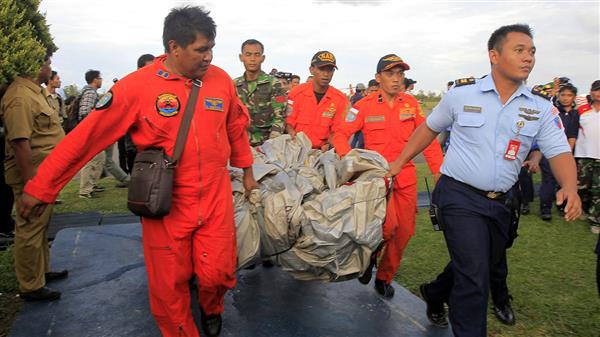 Indonesisk räddningstjänst bärgar vrakdelar från det kraschade planet.