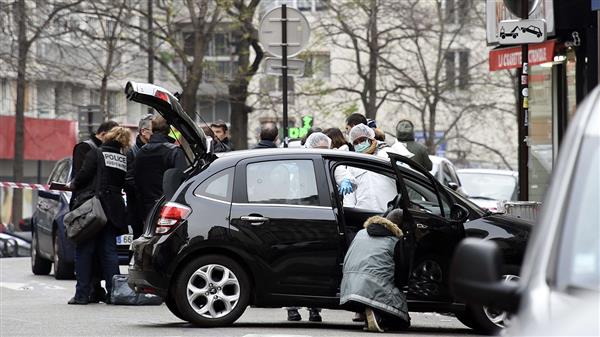 Franska poliser och kriminaltekniska experter undersöker den bil som männen troligen använde när de flydde.