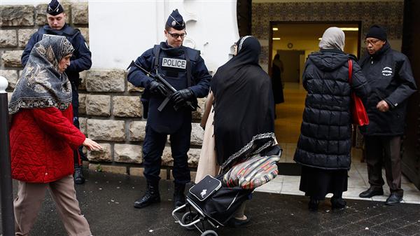 Franska polisen står bredvid ingången till en moské i Paris, dit franska muslimer kommer för fredagsbönen.