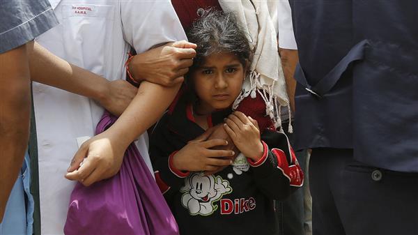 En flicka håller tag i sina mamma under det kraftiga efterskalvet tidigare idag. Foto: TT