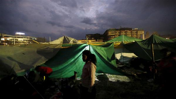 En flicka står utanför sitt tält i Katmandu. Foto: TT