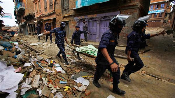 Räddningsteam bär ut döda ur rasmassorna från en byggnad i Baktapur, en förort till Katmandu. Foto: TT