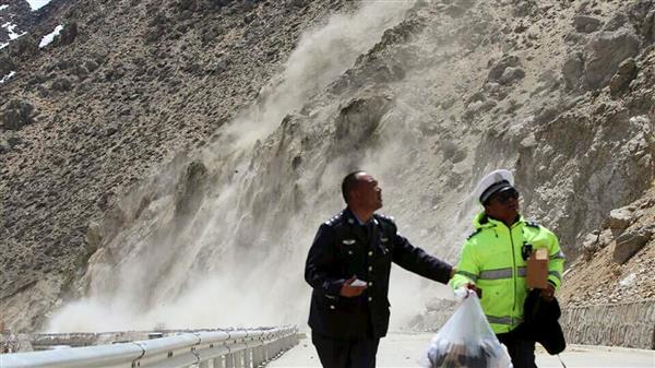 Två män flyr ett jordsked som utlöstes i Nyalam,Tibet, av jordbävningen. Foto: TT