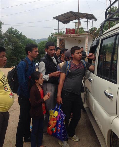 Sayas som lutar sig mot bilen i bilden försöker få skjuts. Bussarna går sällan och gick inte alls efter jordskalvet.