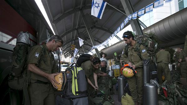 Israeliska soldater,  del av en hjälpdelegation, förbereder sin utrustning inför att lämna flygplatsen utanför Tel Aviv och resa till Nepal. Foto: TT