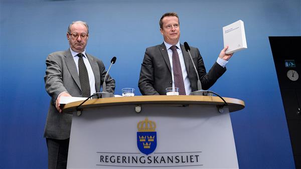 Inrikesministern och utredaren med kommissionens rapport.