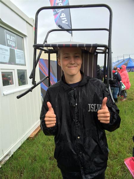 Festivalbesökaren Axel Eliasson tar skydd mot regnet!