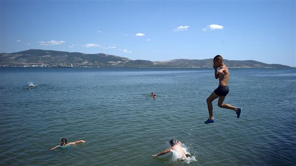 En annan sida av Grekland. Samtidigt som miljontals ska ha köat till vallokalerna passade några på att njuta av ett svalkande dopp. Här vid Elefsina, en strand nära Aten. Foto: TT