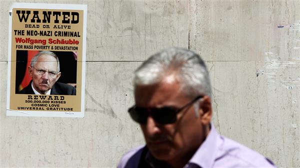 Utanför en bank i Aten hängde besvikna greker upp kritiska posters på Tysklands finansminister. Många befarar nu protester i Aten efter beskedet om uppgörelsen.