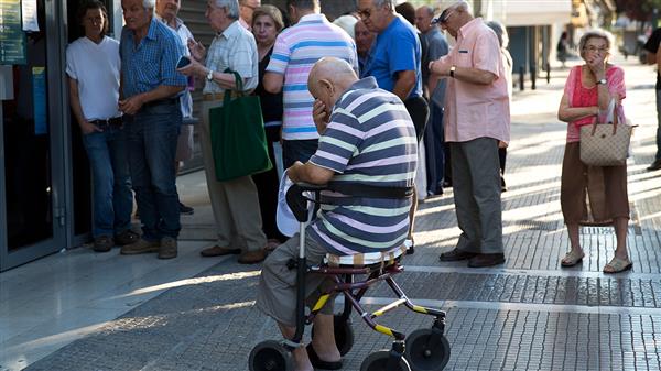 Pensionärer köar till bankomaten i Aten i dag. I två veckor har grekerna inte kunnat ta ut mer än 60 euro om dagen från de stängda bankernas automater.