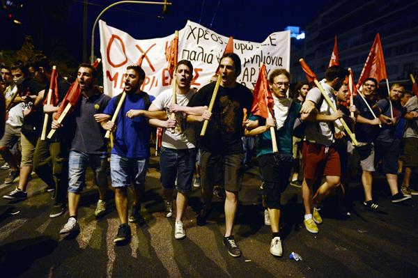 Demonstranter framför grekiska parlamentet protesterar mot premiärminister Tsipras överenskommelse med Eurogruppen om hårda åtstramningar. Foto: TT