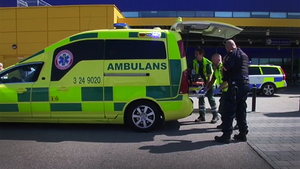 Ambulanspersonal hjälper en av de skadade efter knivdådet på Ikea i Västerås.