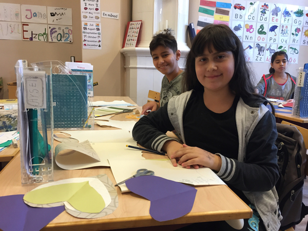 Nu har vi fått följa med på bildlektion. Aysel, 11 år, klipper ut hjärtan från gamla tapeter. Hon kommer från Azerbajdzjan och har varit här några månader. Hon både pratar och förstår svenska ganska bra.