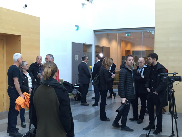 Ett stort medieuppbåd väntar på att bli insläppta i rättssalen. Om ca tio minuter börjar rättegången.