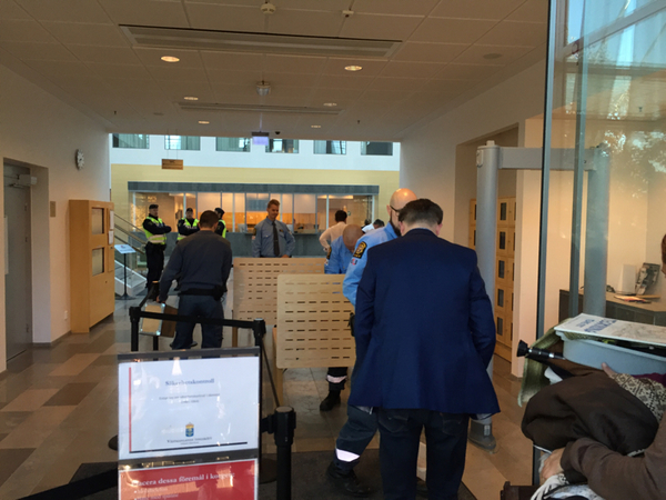 Säkerhetskontrollerna är rigorösa för att komma in i rättssalen eftersom det anses finnas en förhöjd hotbild. Alla väskor gås igenom och man får passera en metalldetektor. Som på en flygplats. Polisen menar att det finns risk för dåd med rasistiska förtecken.
