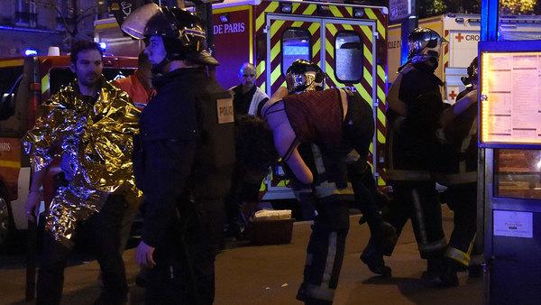 Polis evakuerar en kvinna utanför konsertlokalen Bataclan. Foto: TT