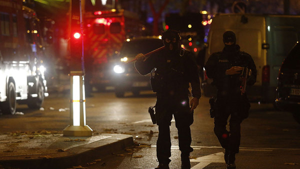 Poliser ur insatsstyrkan går omkring i området runt konsertlokalen Bataclan. Foto: TT