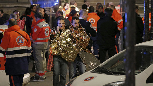 Människor tas omhand utanför konsertlokalen Bataclan. Foto: TT