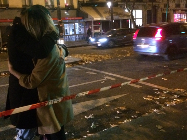 Ett ungt par står strax innanför avspärrningarna. De gråter och kramar varandra. Där borta vid de gula markiserna, på andra sidan gatan, ligger Bataclan. De brukar gå dit. Mer känns inte rätt att fråga just nu...