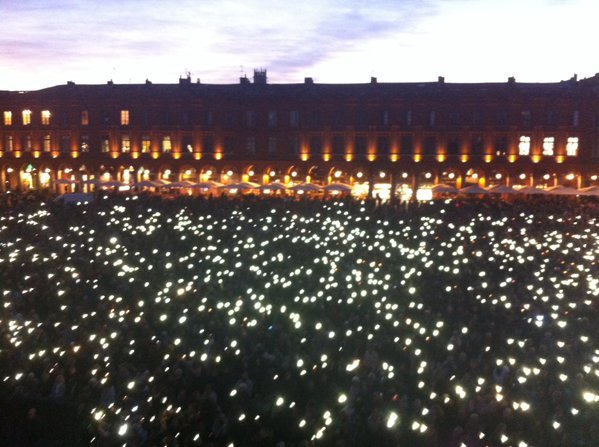 Téléphones portables vers le ciel la foule se recueille en silence 

