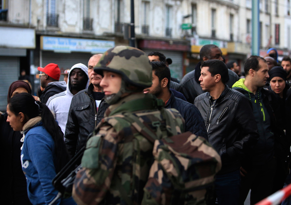 Boende i Saint-Denis motas bort från området där polisens insats pågår. Foto: AP/TT.