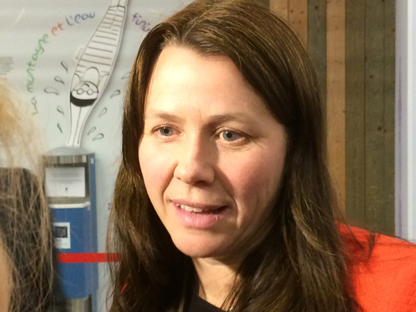En nöjd och glad Åsa Romson kommer ut från plenum.