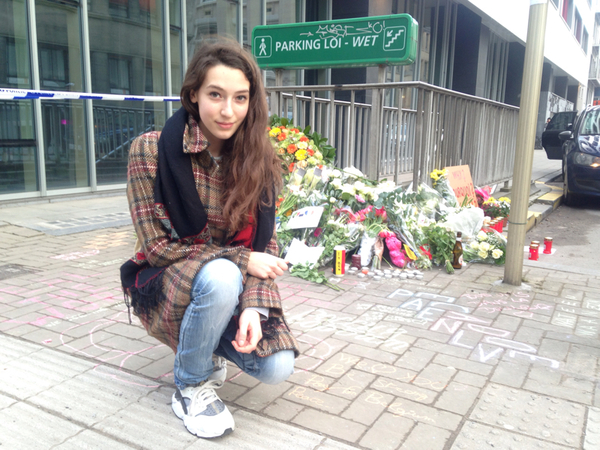 Skådespelarstudenten Brigitta Skarpalezos framför blommorna och ljusen i korsningen rue de la loi / rue d'arlon aarlen.