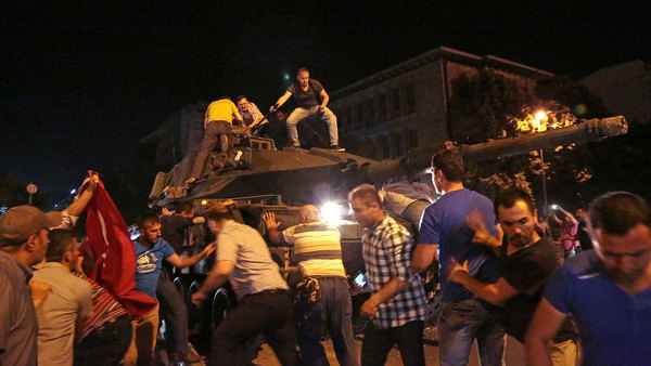 Människor försöker stoppa stridsvagnar som rullar på Ankaras gator.