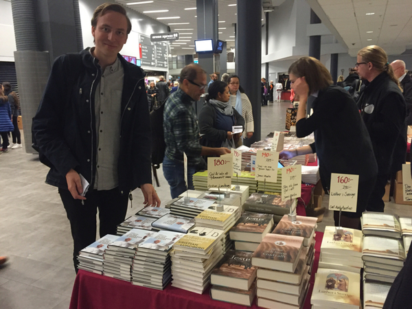 En del av besökarna på arenan tittar inte på själva gudstjänsten. Henrik Syrjä passar istället på att köpa en bok om påven. "Den ska min morfar få".