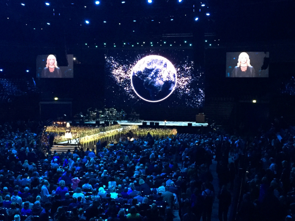 På scenen i Malmö arena står konferencier Kattis Ahlström och säger att påven nu är på väg hit: "Vi väntar på dig"