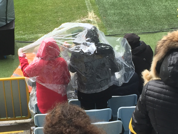 Några som försöker ta skydd från regnet här på stadion.