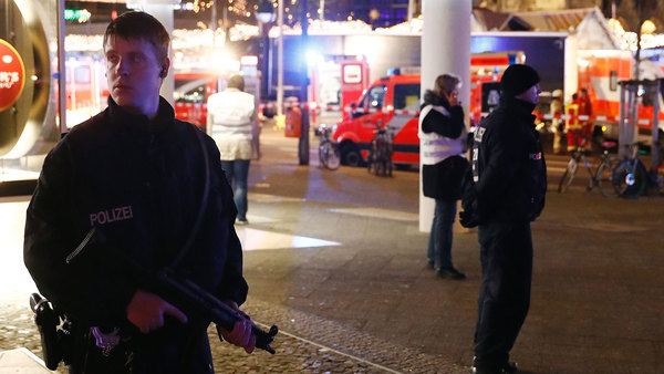 Beväpnad polis bevakar det avspärrade området kring marknadsplatsen. Foto: TT.