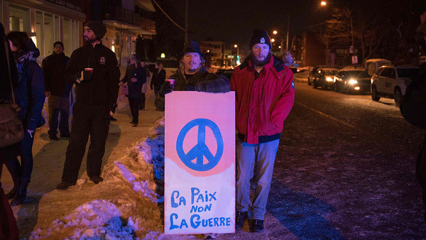 Människor visar sitt stöd för de drabbade vid avspärrningarna i Quebec. "Fred, inte krig". Foto: TT