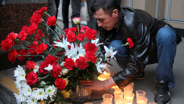 En man läger blommor utanför tunnelbanestationen Sennaja Plosjtjad. Foto: TT