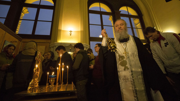 En präst i ortodoxa kyrkan håller minnesgudstjänst i S:t Petersburg efter explosionen. Foto: TT