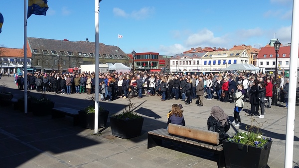Halmstads kommun uppmanade sina anställda att delta i den tysta minuten och strax innan lunch samlades människor vid trappan utanför rådhuset. Flaggor var halade på halvstång och efter den tysta minuten hissades de i topp. Foto: SVT