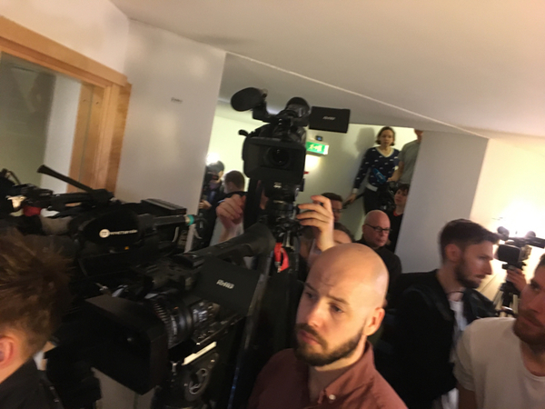 Extremt trångt i källaren framför dörren till säkehetssalen. Mycket media på plats, både utländska och svenska.