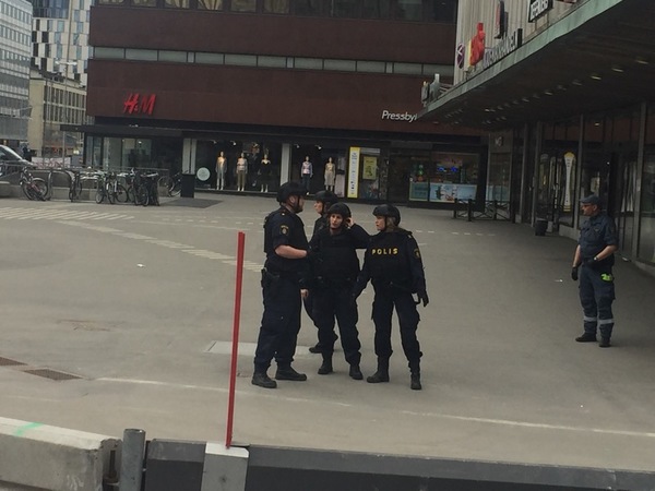 Poliser samlade innanför avspärrningarna.