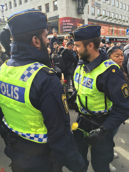 En man stoppar två poliser för att ge blommor och kramar. "För att ni förtjänar det", sa han.