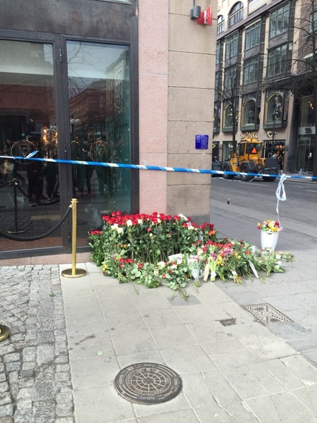 Flera olika blomsterhögar har bildats runt de olika avspärrningarna. Många köper sina blommor går på Hötorget där stämningen är väldigt dämpad en dag som denna.