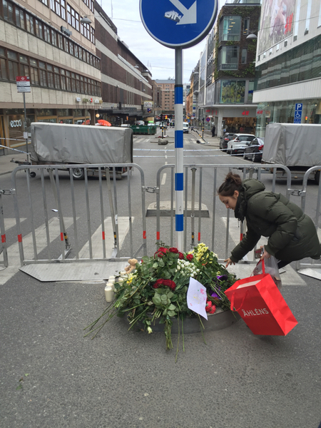 Vid korsningen mellan Mäster Samuelsgatan och Slöjdgatan lämnar människor nu blommor till minne av offren.