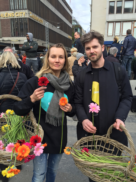 Joakim och Bara delar ut blommor till människor som har samlats utanför Åhléns.
-Bara så att folk får en bättre dag, säger Bara.
