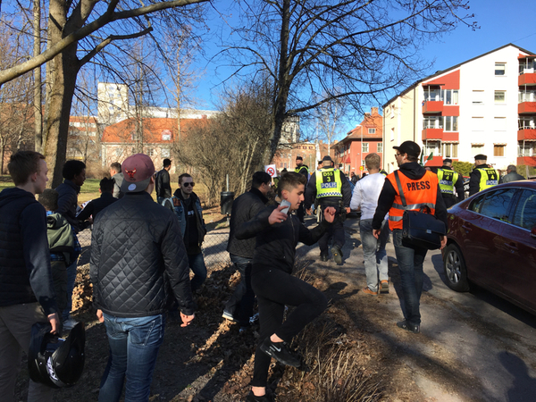 Det blir lite stökigt nu men polisen stänger ute motdemonstranterna som följer efter nordiska motståndsrörelsen