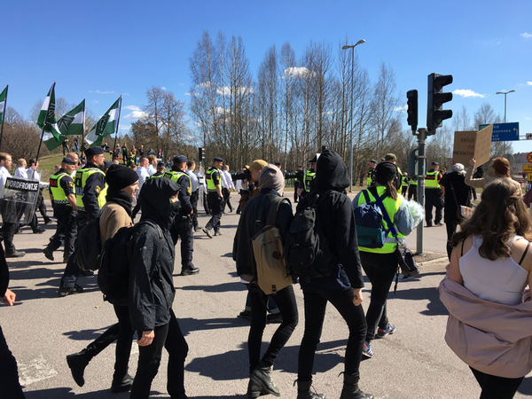 Motdemonstranterna följer tåget och skanderar "inga nazister på våra gator"