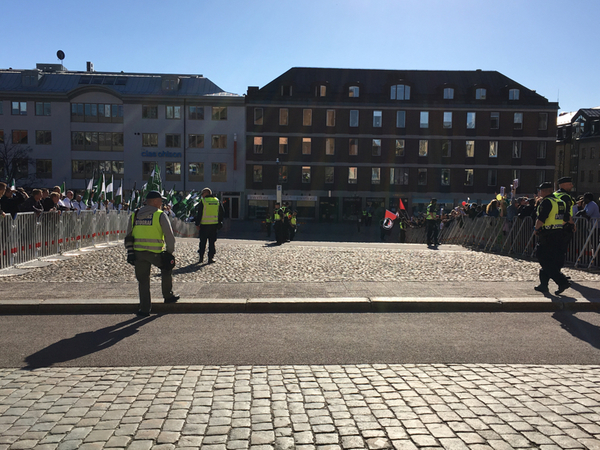 Polisen går in mellan demonstranterna. Tanken är nu att Nordiska motståndsrörelsen ska lämna torget om en stund under polisbevakning