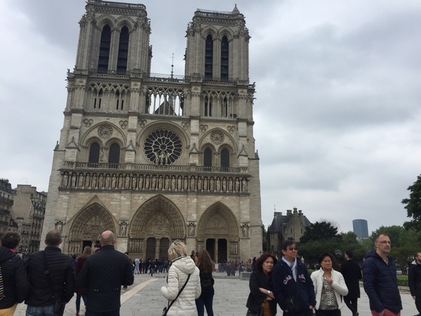 Utanför Notre-Dame, ett av Paris mest ikoniska landmärken, flyter turisttrafiken på som vanligt.